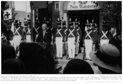 Mitglieder der Bürgerwehr der Heimatvereinigung "Oald Bensem" vor dem Rathaus auf dem Bensheimer Marktplatz während der Eröffnung des 3. Bergsträßer Winzerfestes 1931 in Bensheim. Am Rednerpult Dr. Rudolf Angermeier (1876 - 1952), Bürgermeister der Stadt Bensheim (1922 - 1933), sowie Joseph Stoll (ganz rechts), der Vorsitzende des Bensheimer Verkehrsvereins und Initiator der Winzerfestes sowie Gründer der Bensheimer Heimatvereinigung.; Kennung: NLJS_Fotoalbum_Winzerfestumzug_1932_0117 Mitglieder der Bürgerwehr der Heimatvereinigung "Oald Bensem" vor dem Rathaus auf dem Bensheimer Marktplatz während der Eröffnung des 3. Bergsträßer Winzerfestes 1931 in Bensheim. Am Rednerpult Dr. Rudolf Angermeier (1876 - 1952), Bürgermeister der Stadt Bensheim (1922 - 1933), sowie Joseph Stoll (ganz rechts), der Vorsitzende des Bensheimer Verkehrsvereins und Initiator der Winzerfestes sowie Gründer der Bensheimer Heimatvereinigung.; Kennung: Album_Oald_Bensem_und_Buergerwehr_Bild_0117