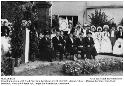 Einweihung des Josef Stoll-Platzes am 5. Oktober 1957. Blick auf die Ehrengäste (v.l.n.r): Margarete Stoll, Egon Stoll-Berberich, Maria Stoll-Berberich, Jürgen Stoll-Berberich, unbekannt; stehend dahinter die Biedermeiergruppe der Heimatvereinigung Oald Bensem.; Kennung: NLJS_00073d