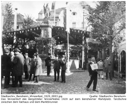 Eindrücke vom Winzerdorf für das erste Bergsträßer Winzerfest 1929, Aufnahme zeigt den Marktbrunnen mit dahinter liegender überdachter Tanzfläche, im Hintergrund die alte Stadtkirche und das Rathaus mit Metzendorf-Fassade; Kennung: Stadtarchiv_Bensheim_Winzerfest_1929_0003