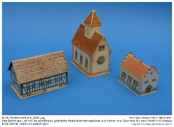 Handgefertigte Kartonmodelle einer Kirche, eines Bauernhofes und eines kleinen Rathauses aus den 1930er bis späten 1940er Jahren im Maßstab 1:87 (H0). Die Gebäude wurden aus grobem Karton gefertigt und mit Papier beklebt, welches zuvor mit Tusche und Aquarell aufwendig gestaltet wurde. Teilweise wurden die fertigen Gebäude mit Klarlack überzogen. Kennung: NLJS_Modelleisenbahn_0014