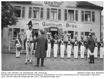 Die Bürgerwehr der Bensheimer Heimatvereinigung "Oald Bensem" vor dem Vereinslokal auf der Hauptstraße in Bensheim 1931, auf dem Pferd der Vereinsgründer und 1. Vorsitzende Joseph Stoll; digitalisiert und zusammengestellt: Frank-Egon Stoll-Berberich, 2023.